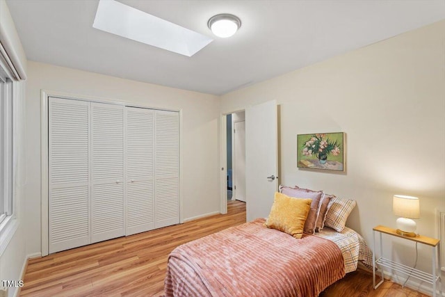1403 Meadow Ln, Chapel Hill, NC 27516 - bedroom with wood finished floors, a closet, and a skylight
