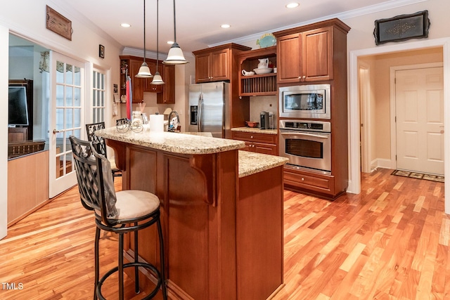 5920 Two Pines Trl, Wake Forest, NC 27587 - kitchen featuring appliances with stainless steel finishes, open shelves, a kitchen breakfast bar, ornamental molding, and light wood-type flooring