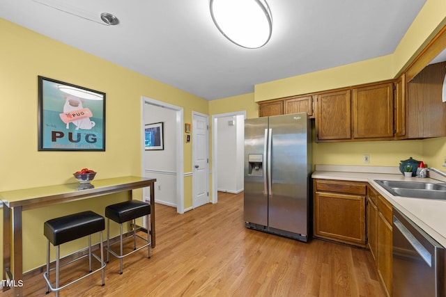 308 Trappers Sack Rd, Cary, NC 27513 - kitchen with stainless steel appliances, brown cabinetry, light countertops, and light wood-style flooring