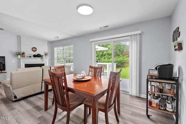611 Quartz Dr, Durham, NC 27703 - dining space with light wood-style flooring and a fireplace