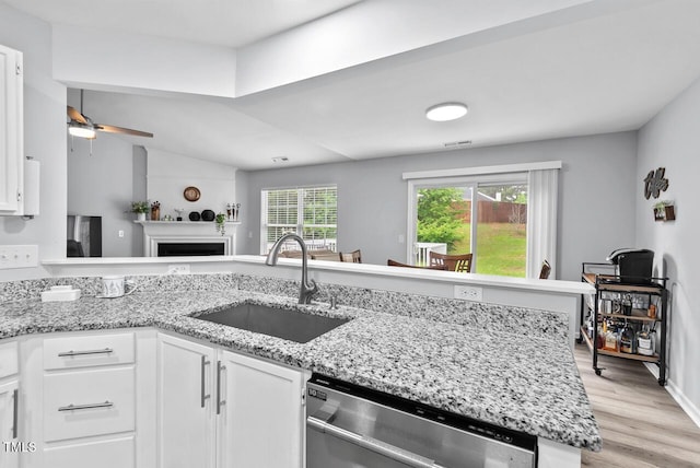 611 Quartz Dr, Durham, NC 27703 - kitchen with stainless steel dishwasher, white cabinetry, a ceiling fan, light wood finished floors, and light stone counters