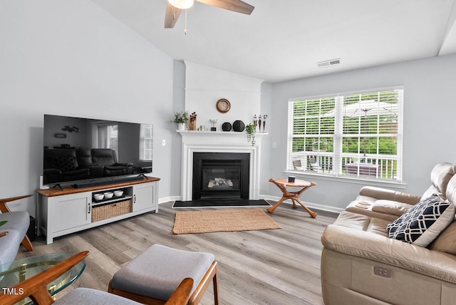 611 Quartz Dr, Durham, NC 27703 - living room with light wood-style floors, a glass covered fireplace, lofted ceiling, and a ceiling fan