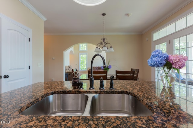 9701 Corktree Ct, Wake Forest, NC 27587 - kitchen featuring ornamental molding, hanging light fixtures, arched walkways, dark stone countertops, and a chandelier