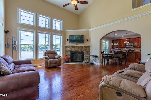 9701 Corktree Ct, Wake Forest, NC 27587 - living room with arched walkways, ceiling fan, a high ceiling, a fireplace, and dark wood finished floors