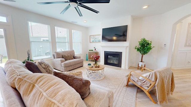 1720 Pinecliff Ct, Fuquay Varina, NC 27526 - living area with arched walkways, light wood-style floors, ceiling fan, a glass covered fireplace, and recessed lighting