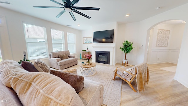 1720 Pinecliff Ct, Fuquay Varina, NC 27526 - living area featuring arched walkways, light wood-type flooring, a ceiling fan, a glass covered fireplace, and recessed lighting