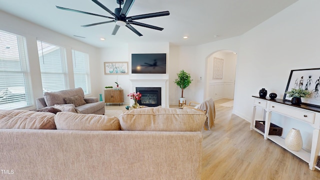 1720 Pinecliff Ct, Fuquay Varina, NC 27526 - living room featuring arched walkways, ceiling fan, light wood-style floors, a glass covered fireplace, and recessed lighting