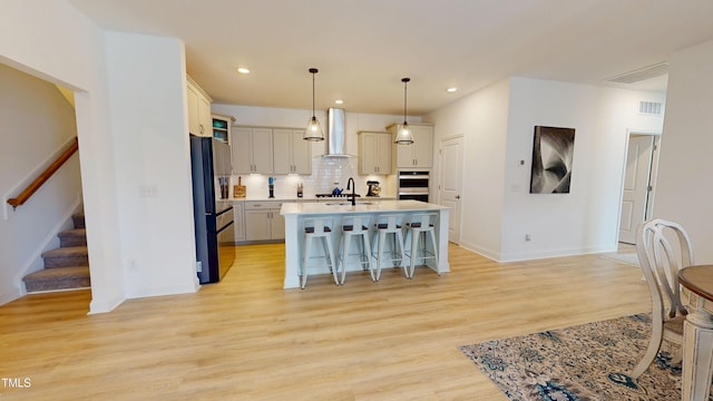 1720 Pinecliff Ct, Fuquay Varina, NC 27526 - kitchen with freestanding refrigerator, a kitchen bar, light countertops, wall chimney exhaust hood, and tasteful backsplash