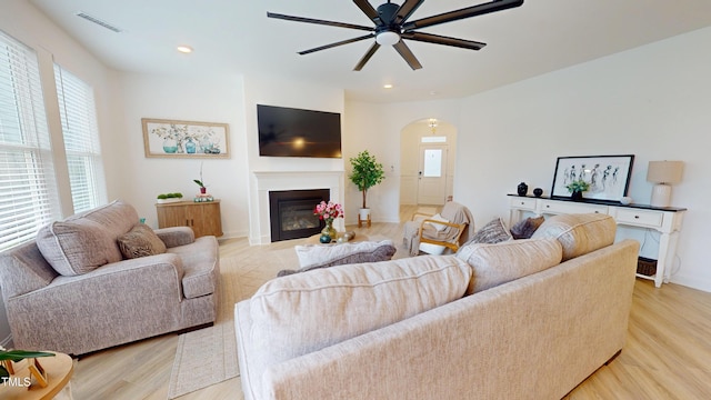 1720 Pinecliff Ct, Fuquay Varina, NC 27526 - living area featuring light wood-style floors, arched walkways, a ceiling fan, a glass covered fireplace, and recessed lighting