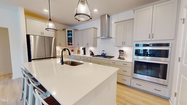 1720 Pinecliff Ct, Fuquay Varina, NC 27526 - kitchen with appliances with stainless steel finishes, wall chimney exhaust hood, backsplash, light wood-type flooring, and recessed lighting