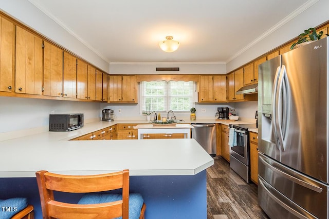 2120 Northcrest Dr, Elon, NC 27244 - kitchen with stainless steel appliances, under cabinet range hood, a peninsula, light countertops, and brown cabinets
