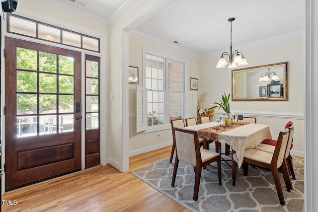23 Northern Way Ct, Durham, NC 27712 - dining area featuring a chandelier, healthy amount of natural light, light wood-style flooring, and crown molding