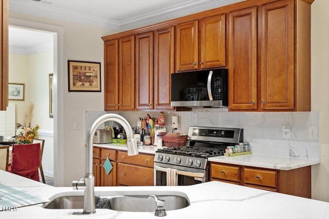 23 Northern Way Ct, Durham, NC 27712 - kitchen featuring stainless steel gas range, tasteful backsplash, brown cabinets, crown molding, and light stone countertops