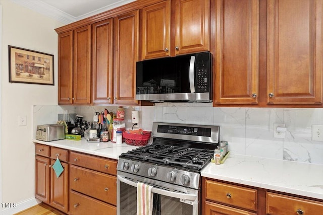23 Northern Way Ct, Durham, NC 27712 - kitchen with stainless steel range with gas stovetop, backsplash, brown cabinetry, crown molding, and light stone countertops