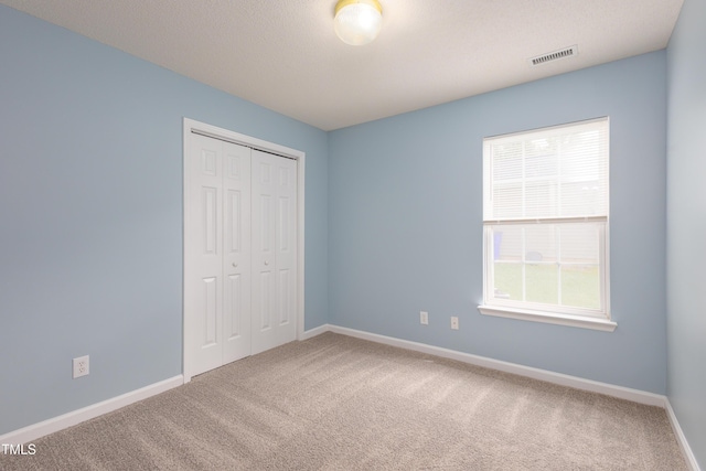418 Lodestone Dr, Durham, NC 27703 - unfurnished bedroom with multiple windows, carpet floors, and a closet