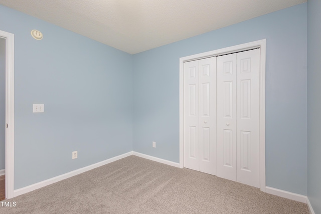 418 Lodestone Dr, Durham, NC 27703 - unfurnished bedroom featuring carpet flooring, a closet, and a textured ceiling