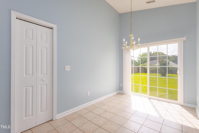 418 Lodestone Dr, Durham, NC 27703 - unfurnished dining area featuring a chandelier, light tile patterned floors, and a towering ceiling