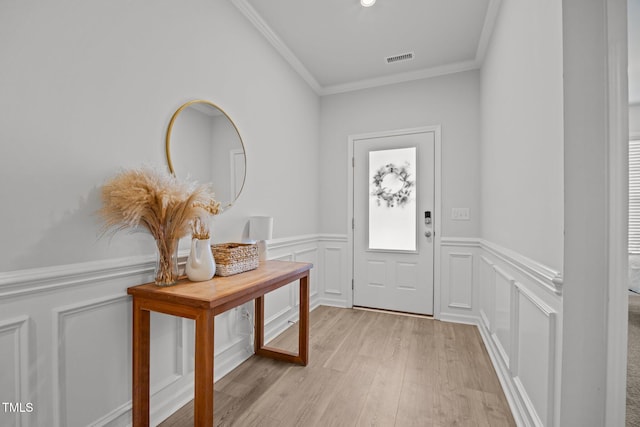 2321 Blue Crab Ct, Wake Forest, NC 27587 - entryway featuring ornamental molding, light wood-type flooring, wainscoting, and a decorative wall