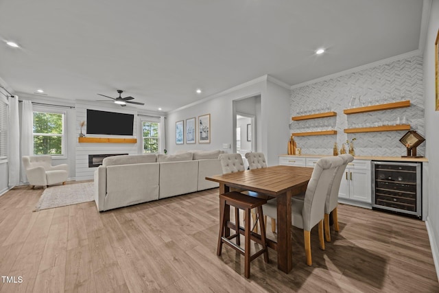 2321 Blue Crab Ct, Wake Forest, NC 27587 - dining area with beverage cooler, ornamental molding, a ceiling fan, light wood finished floors, and bar