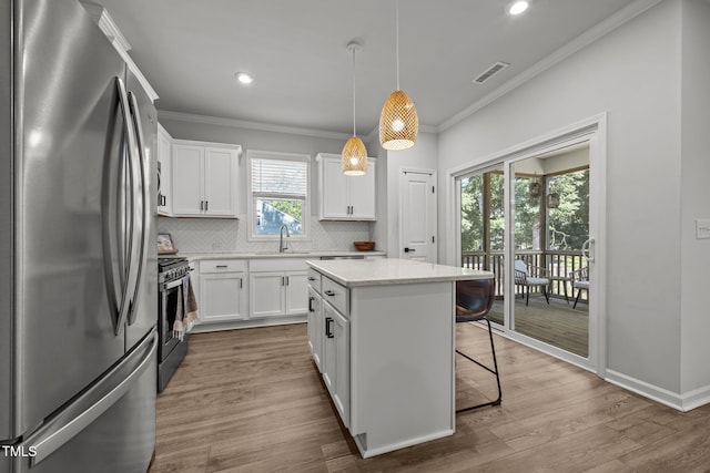 2321 Blue Crab Ct, Wake Forest, NC 27587 - kitchen featuring stainless steel appliances, ornamental molding, decorative backsplash, a kitchen island, and white cabinets