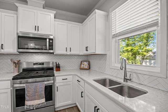 2321 Blue Crab Ct, Wake Forest, NC 27587 - kitchen featuring stainless steel appliances, white cabinets, tasteful backsplash, light stone countertops, and crown molding