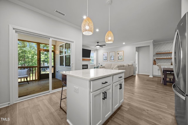 2321 Blue Crab Ct, Wake Forest, NC 27587 - kitchen with ornamental molding, a glass covered fireplace, freestanding refrigerator, light wood-style flooring, and a ceiling fan