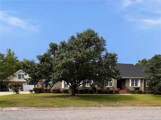 333 Westwater Way, Fayetteville, NC 28301 - obstructed view of property featuring a front lawn, driveway, an attached garage, and brick siding