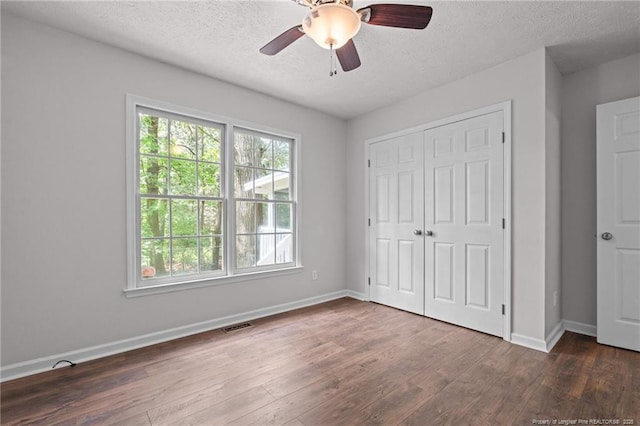 40 Blue Heron Ct, Sanford, NC 27332 - unfurnished bedroom with multiple windows, a textured ceiling, dark wood-style floors, a closet, and ceiling fan