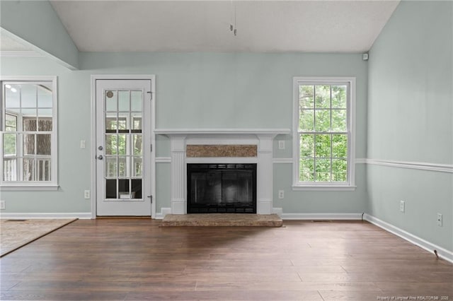 40 Blue Heron Ct, Sanford, NC 27332 - unfurnished living room with wood finished floors, a glass covered fireplace, plenty of natural light, and vaulted ceiling