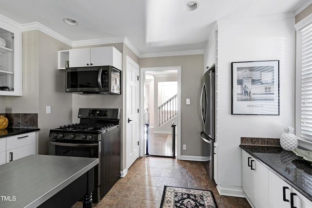 627 New Rd, Raleigh, NC 27608 - kitchen with black range with gas cooktop, freestanding refrigerator, ornamental molding, white cabinets, and stone tile flooring