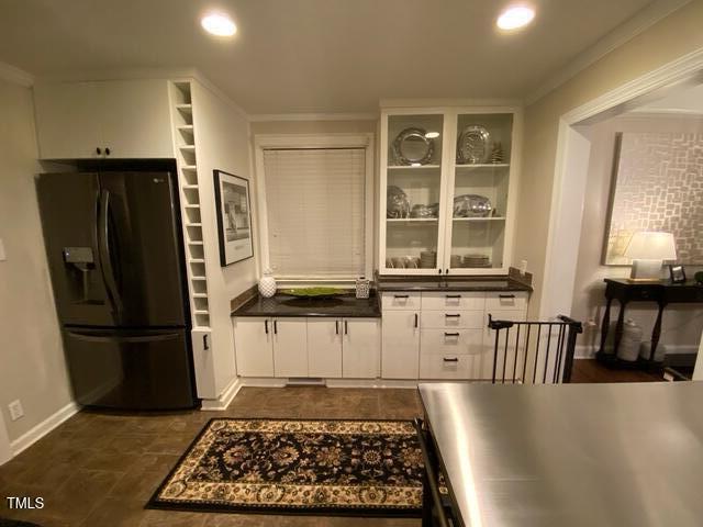 627 New Rd, Raleigh, NC 27608 - kitchen with fridge with ice dispenser, dark countertops, crown molding, white cabinets, and recessed lighting