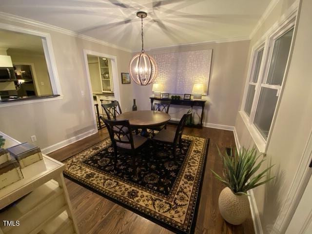 627 New Rd, Raleigh, NC 27608 - dining space featuring dark wood-style flooring, a chandelier, and crown molding