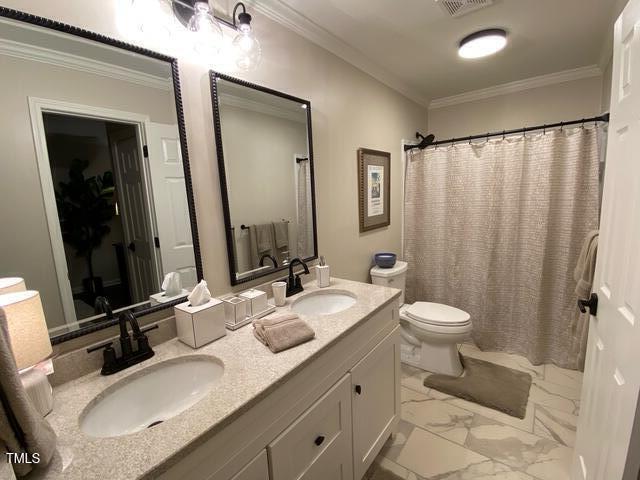 627 New Rd, Raleigh, NC 27608 - bathroom with marble look tiles, double vanity, ornamental molding, and a shower with shower curtain