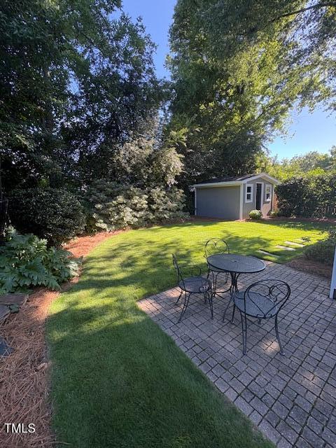 627 New Rd, Raleigh, NC 27608 - view of grassy yard featuring an outbuilding and a patio area