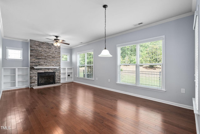 1104 Gaston Manor Dr, Durham, NC 27703 - unfurnished living room with a ceiling fan, dark wood-style flooring, crown molding, a stone fireplace, and built in shelves