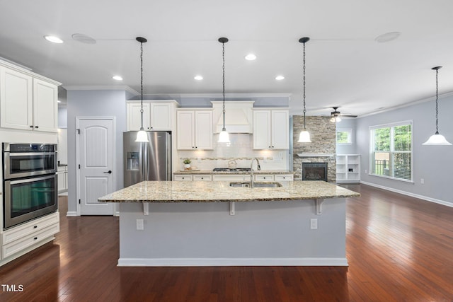 1104 Gaston Manor Dr, Durham, NC 27703 - kitchen with stainless steel appliances, a ceiling fan, ornamental molding, light stone countertops, and white cabinets