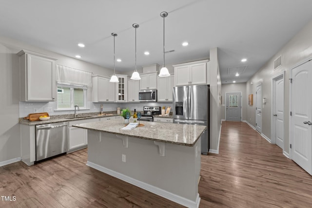 119 Yadkin St, Clayton, NC 27520 - kitchen with stainless steel appliances, a center island, white cabinets, a kitchen breakfast bar, and dark wood-style floors
