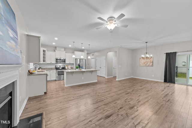 119 Yadkin St, Clayton, NC 27520 - unfurnished living room with a fireplace, a ceiling fan, recessed lighting, light wood-style flooring, and a chandelier