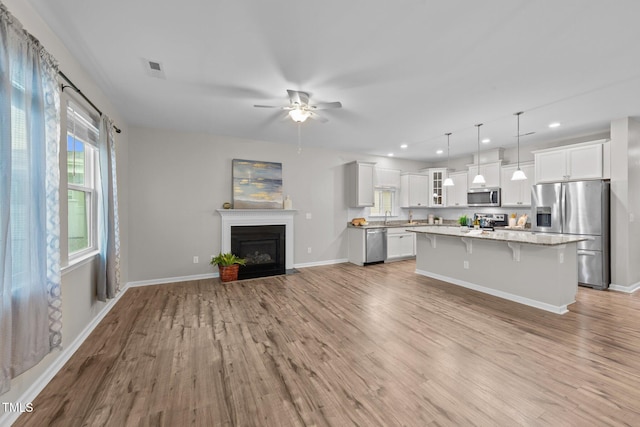 119 Yadkin St, Clayton, NC 27520 - unfurnished living room with ceiling fan, light wood finished floors, a fireplace with flush hearth, and recessed lighting