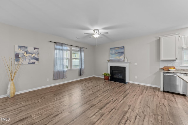 119 Yadkin St, Clayton, NC 27520 - unfurnished living room featuring light wood-type flooring, a ceiling fan, plenty of natural light, and a fireplace