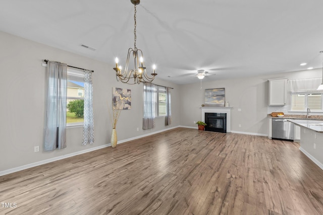 119 Yadkin St, Clayton, NC 27520 - unfurnished living room with wood finished floors, a glass covered fireplace, a chandelier, ceiling fan, and recessed lighting