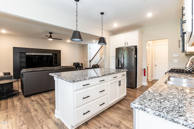 9 Moss Side Ter, Durham, NC 27703 - kitchen featuring stainless steel refrigerator with ice dispenser, wood finished floors, ceiling fan, pendant lighting, and light stone counters