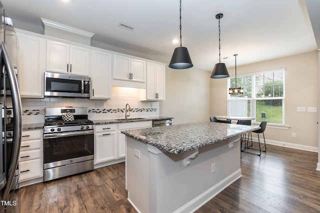9 Moss Side Ter, Durham, NC 27703 - kitchen featuring stainless steel appliances, a kitchen island, backsplash, and white cabinetry