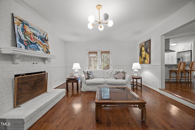 926 Wimbleton Dr, Raleigh, NC 27609 - living area with wood finished floors, a chandelier, a fireplace, and a wainscoted wall