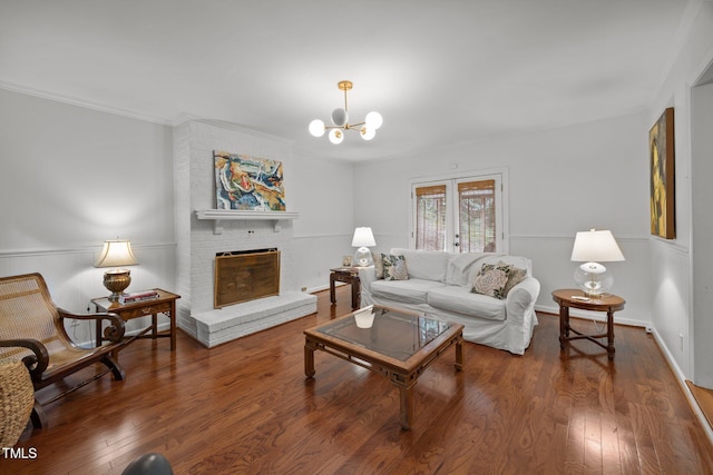 926 Wimbleton Dr, Raleigh, NC 27609 - living room featuring a brick fireplace, wood finished floors, a chandelier, and crown molding