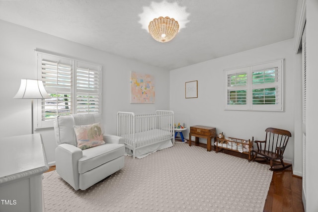926 Wimbleton Dr, Raleigh, NC 27609 - bedroom featuring multiple windows, wood finished floors, and a nursery area