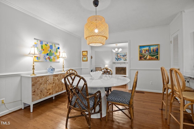 926 Wimbleton Dr, Raleigh, NC 27609 - dining space with wood finished floors, crown molding, and a wainscoted wall