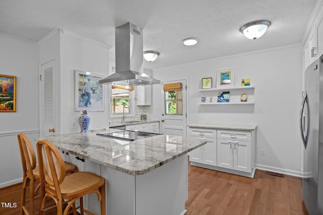 926 Wimbleton Dr, Raleigh, NC 27609 - kitchen featuring island range hood, freestanding refrigerator, a peninsula, open shelves, and ornamental molding