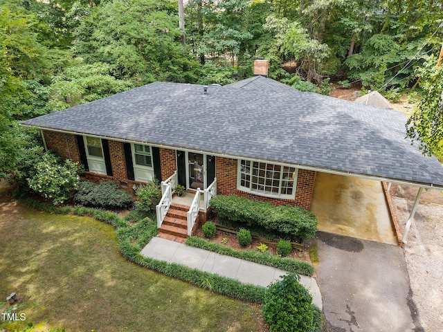 926 Wimbleton Dr, Raleigh, NC 27609 - ranch-style house with a shingled roof, a chimney, an attached carport, brick siding, and a porch