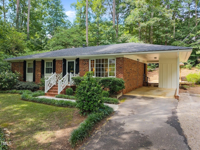 926 Wimbleton Dr, Raleigh, NC 27609 - ranch-style house with asphalt driveway, brick siding, an attached carport, and roof with shingles